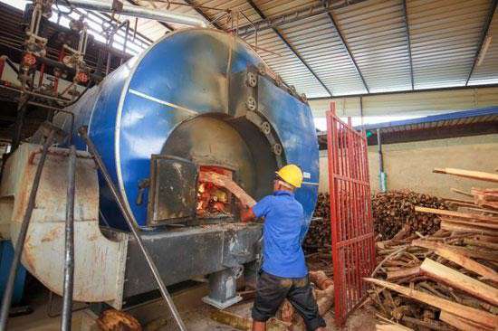 Operator working at an industrial biomass boiler